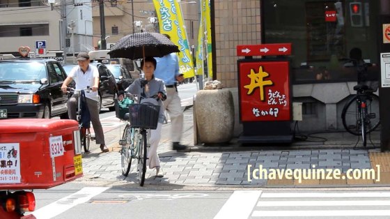 Ciclista mulher com guarda-chuva na bike para se proteger do sol