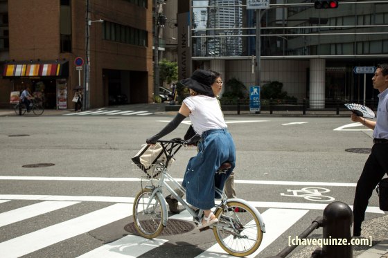 Ciclista mulher vestindo luvas compridas, estilo manguito, em Osaka, Japão.